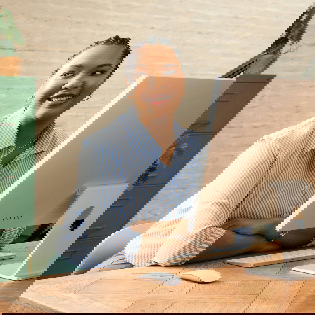 A woman smiling while working at a computer